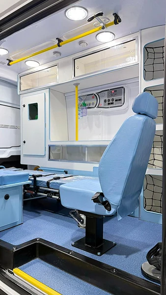 Detalhe da poltrona azul e dos armários no interior de uma ambulância