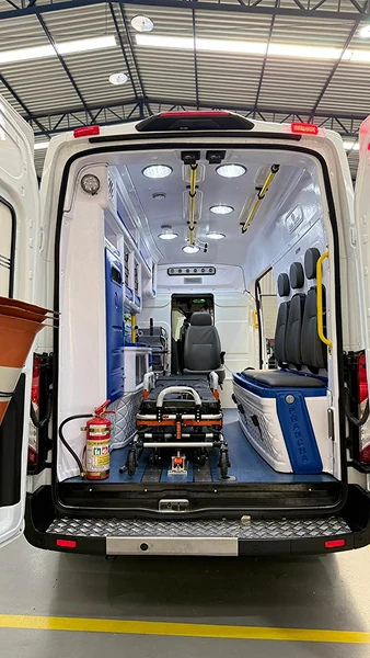 Vista traseira de ambulância com maca e compartimentos azuis