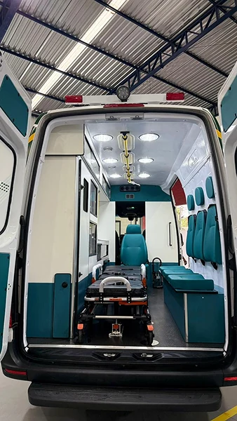 Vista traseira de ambulância com maca e assentos turquesa