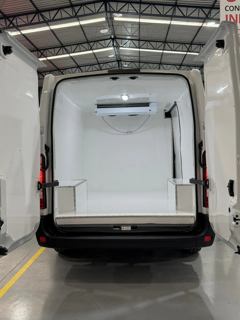 Compartimento branco de van com unidade de refrigeração e portas traseiras abertas