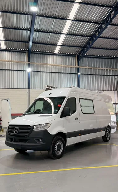 Veículo especial branco Mercedes-Benz em vista frontal e lateral no galpão