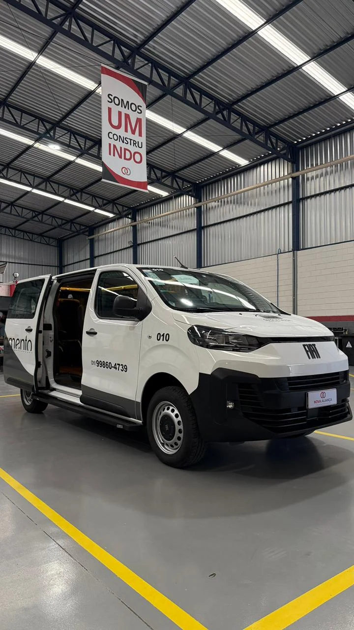 Van branca Fiat com porta lateral aberta no galpão